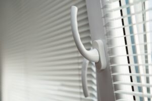 Open plastic window for ventilation. PVC metal blinds on the window frame