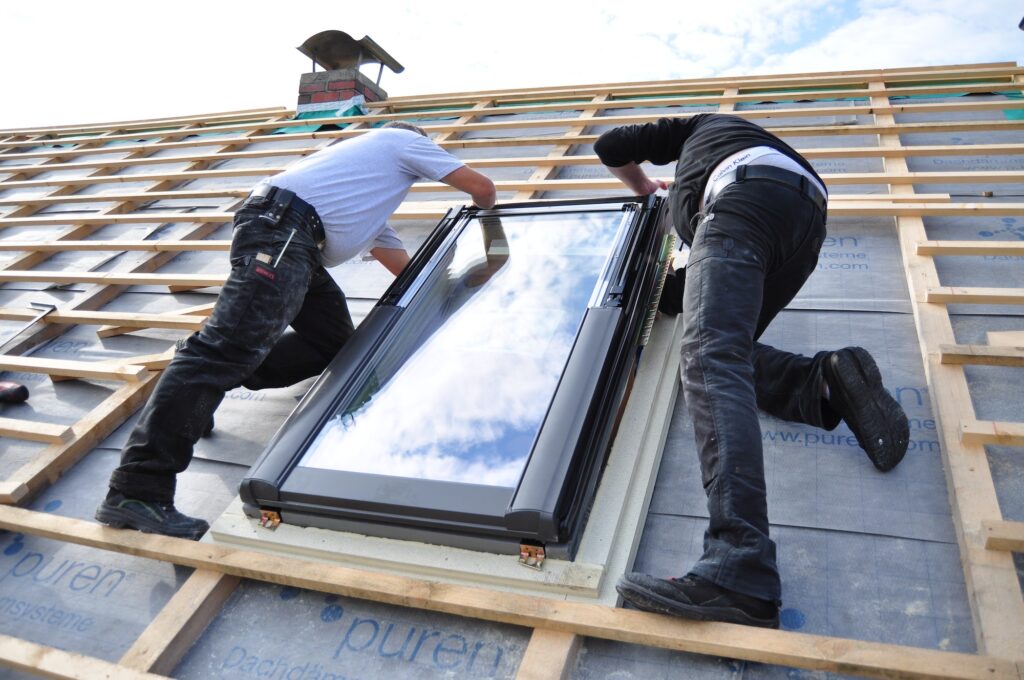 two men assembling a roof skylight window